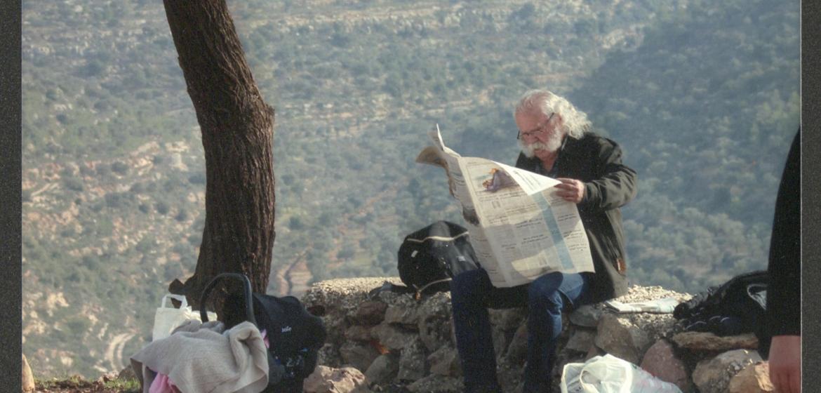 Adel Tartir unter einem Baum am Zeitung lesen. Foto: www.adeltartir.com