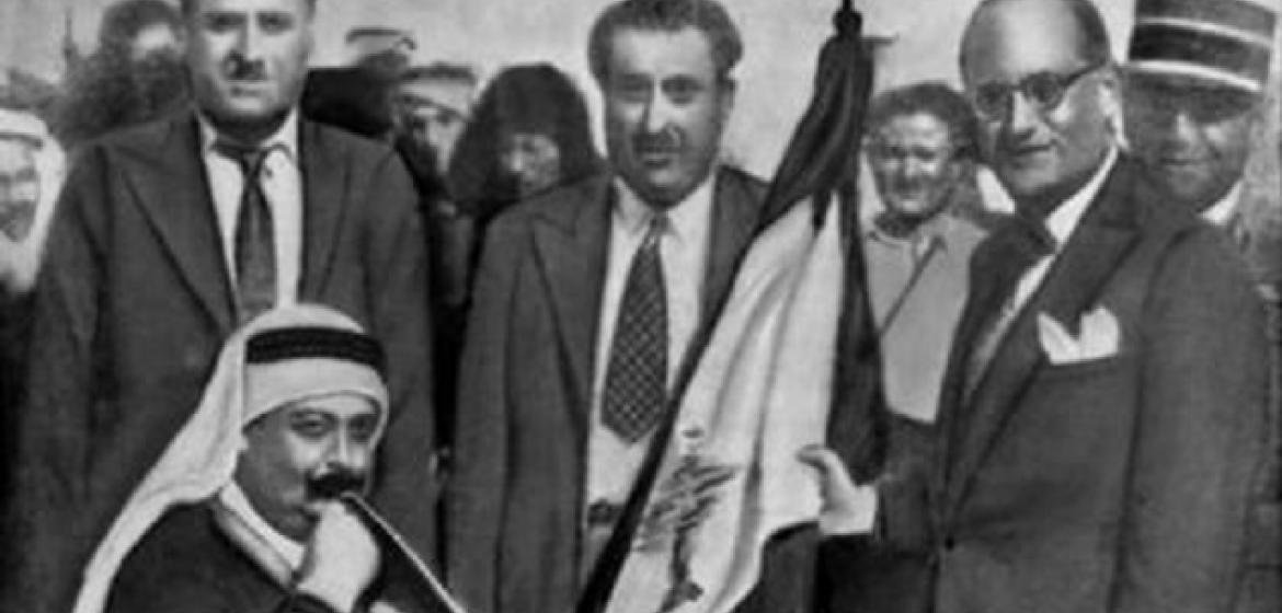 Emir Majid Arslan küsst die erste libanesische Flagge am 22. November 1943. Er war Anführer der Nationalgarde.In der Mitte Präsident Sabri Hamadé. Rechts Premierminister Habib Abou Chahla. Bild: CC-NC Tmaromeo/ Wikicommons