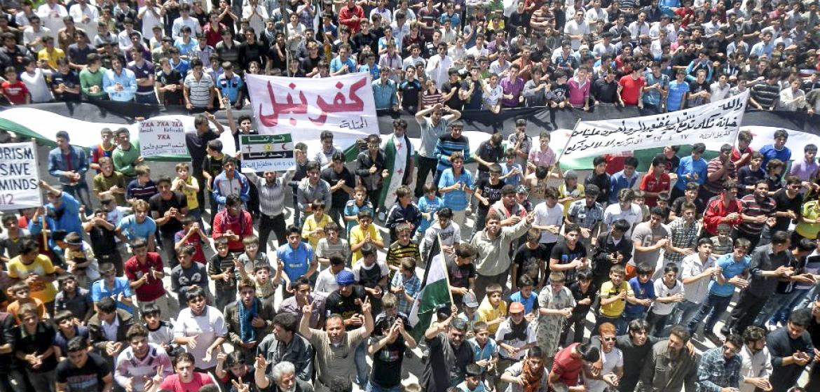 "Die erwachte Zivilgesellschaft ist das verkannte, oftmals unspektakuläre, alltägliche, kleinformatige und damit wenig medientaugliche Kernelement dessen, was gemeinhin als 'Arabischer Frühling' bezeichnet wird. " Demonstration im besetzten Ort Kafranbel in der syrischen Provinz Idlib. Bild: Freedom House/Flickr (CC-BY-2.0)