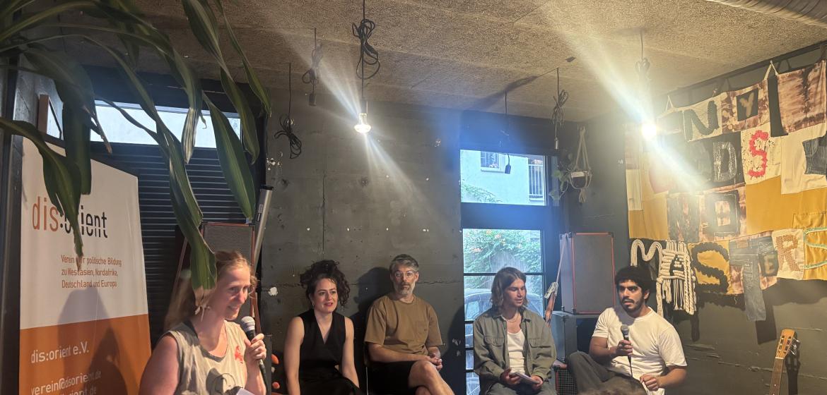 Henriette Raddatz stellt dis:orient vor. Auf dem Podium sitzen die Podcast-Gäste Sarah El Bulbeisi und Tomer Dotan-Dreyfus mit den Hosts Valentin und Kian.