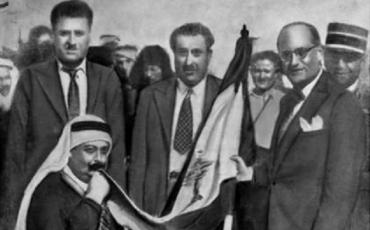 Emir Majid Arslan küsst die erste libanesische Flagge am 22. November 1943. Er war Anführer der Nationalgarde.In der Mitte Präsident Sabri Hamadé. Rechts Premierminister Habib Abou Chahla. Bild: CC-NC Tmaromeo/ Wikicommons