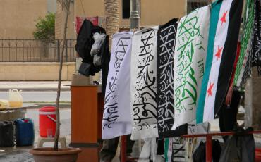 Raqqa, April 2013: with the increasing military gains of Islamist groups, white and black flags appear now more often next to the flag of the Revolution in public space. Photo: cc Beshroffline / flickr.