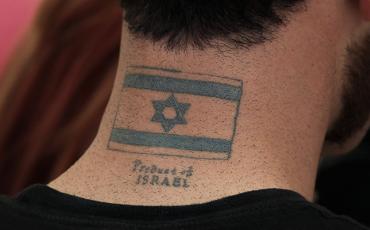 Werbung, die unter die Haut geht. Dieser Mann wirbt sogar in seinem Nacken für Israel. Foto: Tobias Pietsch (C)