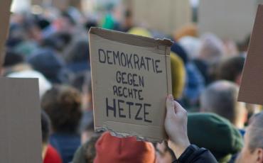 Während der aktuellen Demos gegen rechts werden Forderungen nach einer stärkeren Demokratie laut. Foto: Christian Lue, Unsplash.