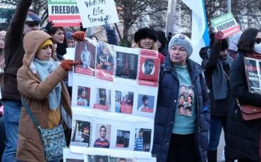 Mansoureh Behkish demonstriert gegen die Hinrichtung von Demonstrant:innen, Dublin 2022. Auf einem Plakat um ihren Hals sind Bilder ihrer Familienmitglieder zu sehen, die während der berüchtigten 1980er-Jahre in Iran gehängt oder getötet wurden. Foto: Mansoureh Behkish, privat