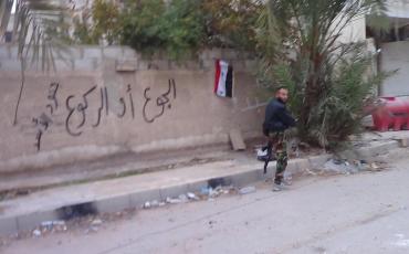 Ein Milizenkämpfer des Regimes steht Wache am Ortseingang des Damaszener Vorortes Moadamiya. Bashar al-Assads Truppen hungerten Moadamiya systematisch aus, wie auch das Graffiti an der Wand besagt: "Hunger oder Niederknien." Der Medienaktivist Qusai Zakarya hat das Foto aus einiger Entfernung gemacht und uns zur Verfügung gestellt (C).