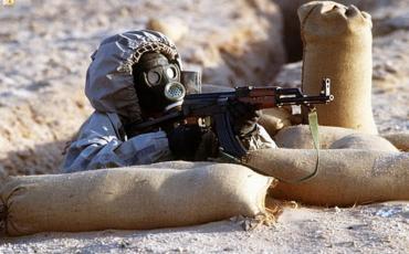 Syrischer Soldat mit Kalaschnikow und Gasmaske. Bild: H.H. Deffner/wikicommons, CC 3.0 https://commons.wikimedia.org/wiki/File:Syrian_soldier_aims_an_AK-47.JPEG