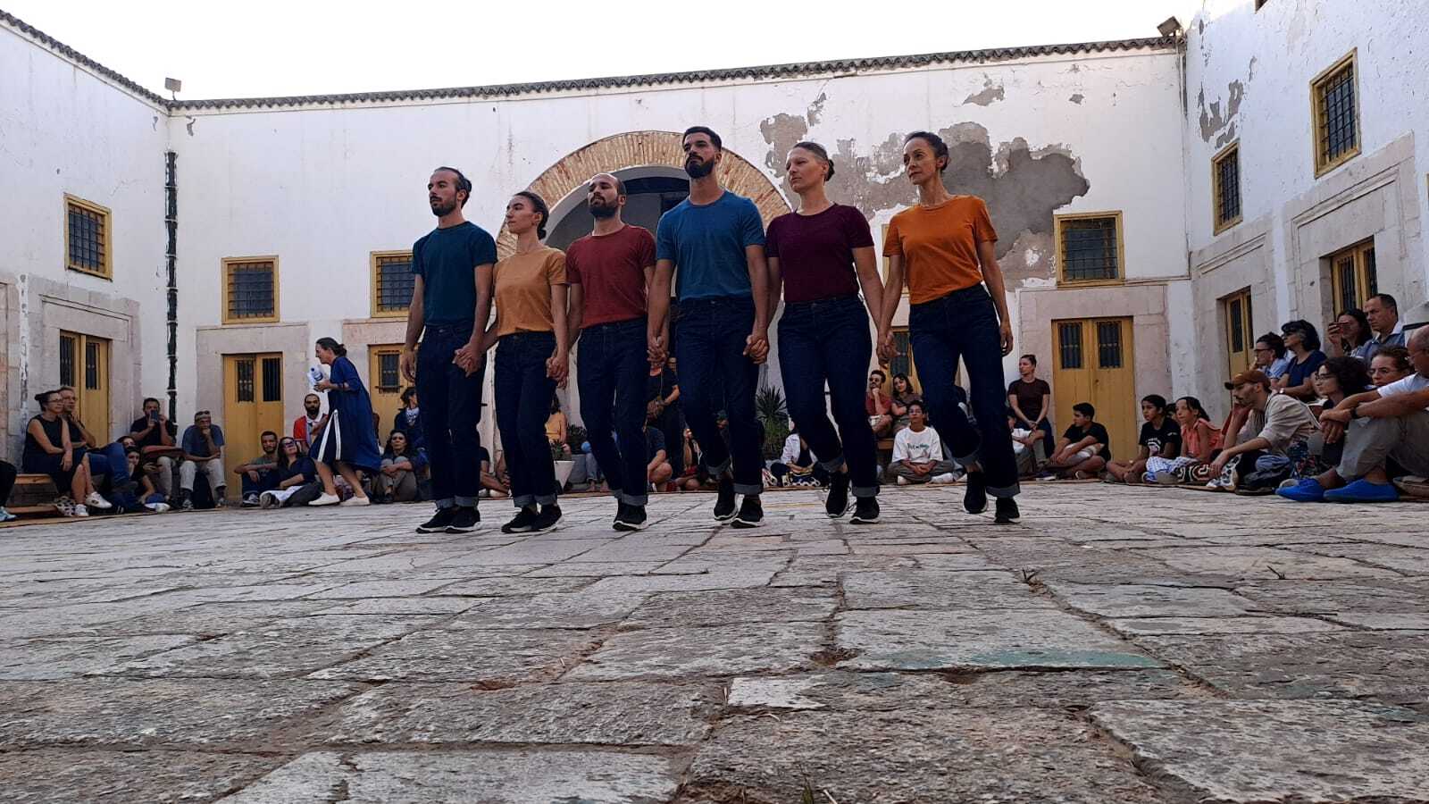 Sechs Tänzer:innen des Stücks "Gouâl in Situ" von Choreograph Felipe Lourenço tanzen in einem Innenhof. Foto: Haroun Ben Youssef
